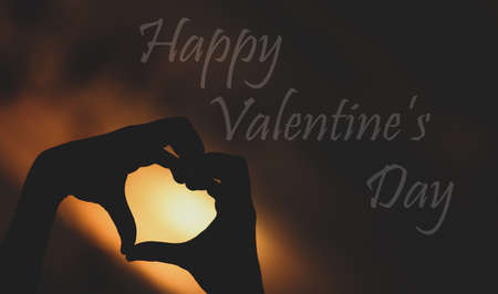 Happy Valentine day with a silhouette of hands making heartの写真素材