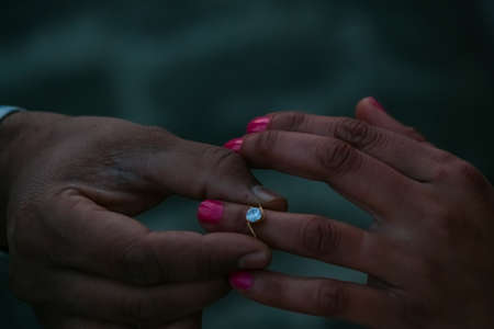 hands of the bride and groom with rings while proposingの写真素材