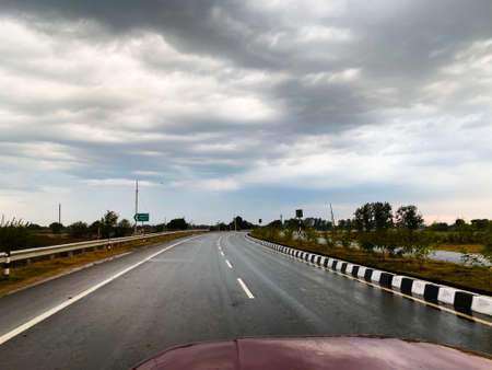 View of empty roads and cloudy sky while driving on a highway in the cityの写真素材