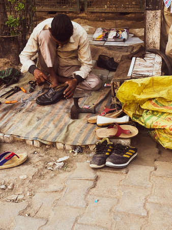 A roadside street cobbler repairing shoesのeditorial素材