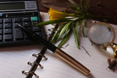 Rustic view of professional desk with calculator notebook and pen on the tableの写真素材