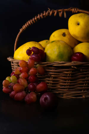 closeup of basket of fruits (mango, grapes)の写真素材