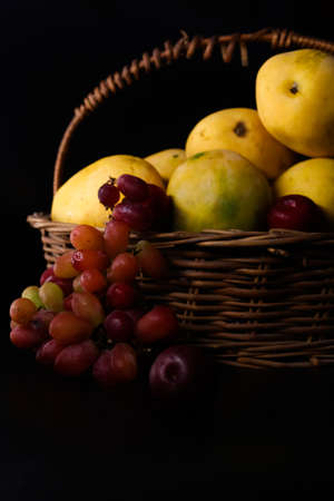 closeup of fresh basket of fruits on black backgroundの写真素材