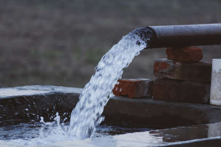 water flowing out from a pipe through motor pump in farmsの写真素材