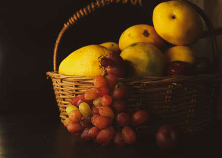 closeup of a basket of fresh farm organic juicy healthy fruits on black backgroundの写真素材