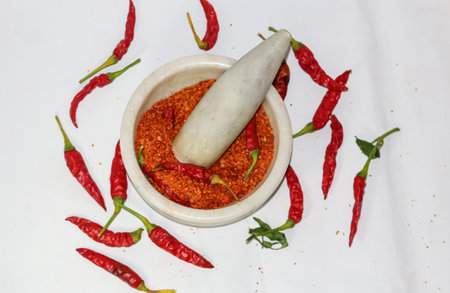 fresh red hot chilli powder from peppers grinded in the motor pestleの写真素材