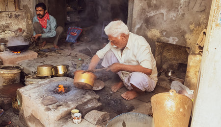 Patiala Punjab India 03 04 2021person on the roadside doing tin canning of the utensil on fire silver coating Kaali old traditionのeditorial素材