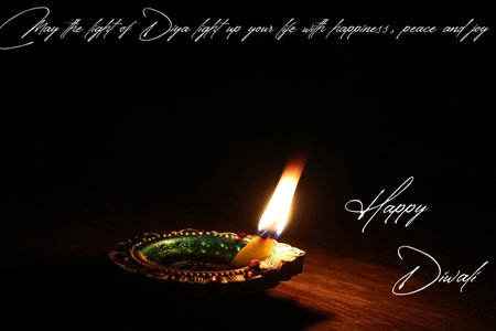 Happy Diwali wishes burning candles diyas on the black background night time celebrationの写真素材