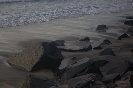 Landscape view of beach in the morning water shores on beach side on rocks and sandの写真素材