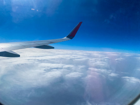 wing view with blue sky and clouds from airplane windowの写真素材