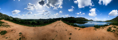 Panaromic landscape with mountains, lake, plantation and blue sky with cloudsの写真素材