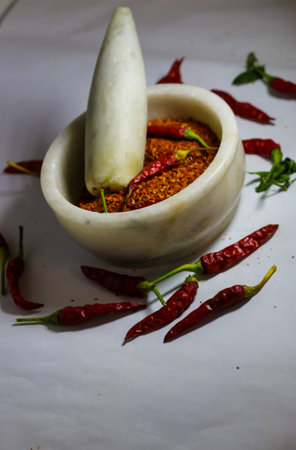 Fresh Red chillies and  powder crushed in motor pestleの写真素材