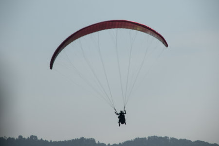 Paraglider flying in the blue sky on a sunny dayの写真素材