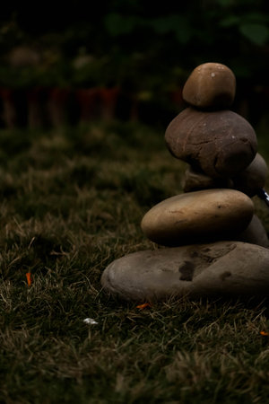 Stack of pebbles on the grass in the garden at nightの写真素材