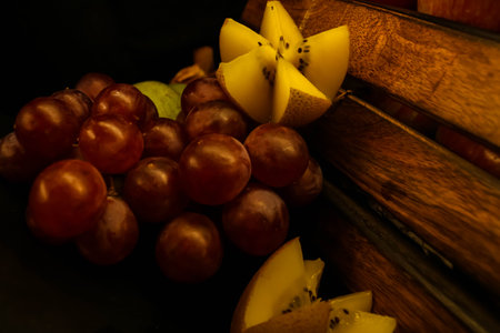 Close-up of fresh healthy fruits (grapes, kiwi) on a wooden bench. Toned.の写真素材