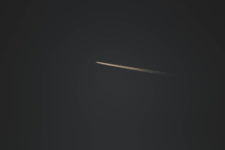 Airplane trail tracks in the sky on a dark background. Airplane in the sky.の写真素材