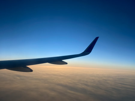 View from airplane window. Airplane wing in the blue sky above the clouds.の写真素材