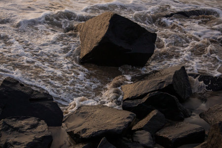 close-up view of rocks with water waves tides splashing. Rocky beach in the evening, Rocky beach textured background wallpaperの写真素材