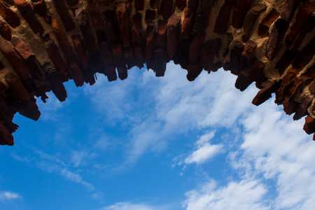 old brick wall with blue sky and white clouds, beautiful photo digital picture. Background wallpaper backdrop design.の写真素材