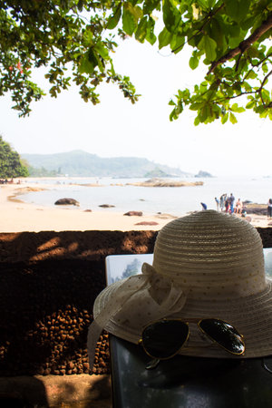 Straw hat and sunglasses on the beach in Gokarana, India. Beach vibes backdrop wallpaperの写真素材