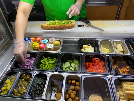 Chef preparing a healthy vegetable sandwich in open kitchen in restaurant. Selective focus.の写真素材