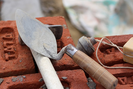 Trowel and other measuring tools on bricks at construction site, closeup of photo. Construction background wallpaper.の写真素材