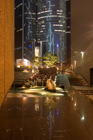 
Fountain on Hong-Kong street lit by advertisement lights and street-lamps
