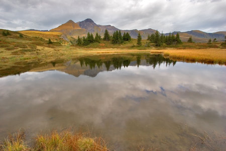  Small fine and smooth lake in the Swiss Alpes, reflecting mountains