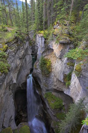 A falls in a narrow and deep canyon in the north of Canadaの写真素材