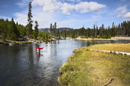 The fisherman in a red diving suit with autoheating in the cold autumn riverの写真素材
