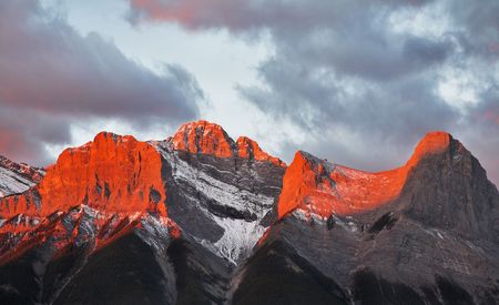 Tops of mountains sparkling by red morning color in northern Canadaの写真素材