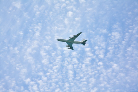 The white plane in the cloudy sky, shined by the sun