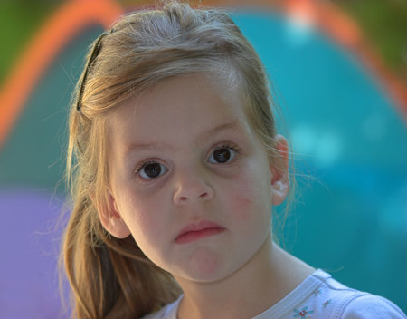 The small serious girl plays to a garden