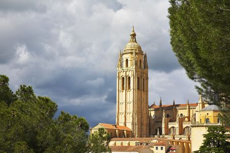 Tower of a cathedral in Segovia on a background of the cloudy skyの写真素材