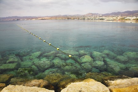  A shallow gulf with the transparent greenish water, surrounded by anchor buoys, in the big southern sea resortの写真素材