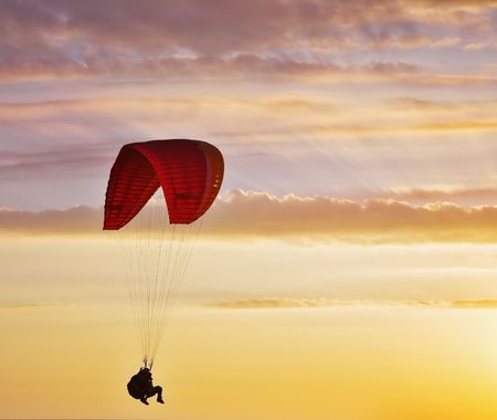 Flight on an operated parachute in twilight on a sunset の写真素材