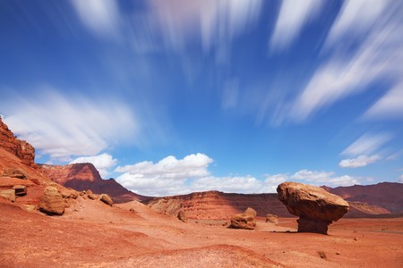 The grand panorama - a stone desert of red sandstone and the famous rock in the form of the fungus. Windy sunny autumn dayの写真素材