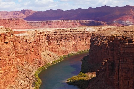 Magnificent Colorado River slowly flows into the high banks of red sandstoneの写真素材