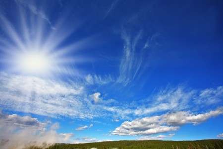 The high dark blue sky with freakish clouds above Yellowstone national parkの写真素材