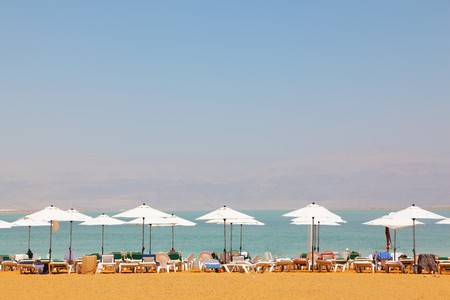 Sun beds, chairs, umbrellas and awnings on the beach luxury hotel on the Dead Sea in Israel. Sunny spring dayの写真素材