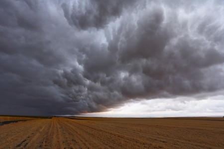 A huge and terrible storm cloud, illuminated by a pink sunsetの写真素材