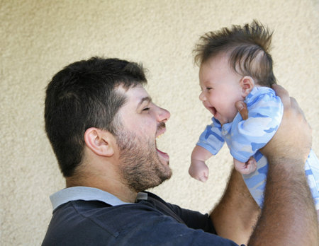 A handsome young father playing with his cute little son
