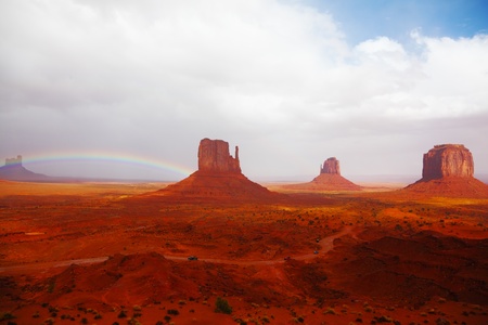 Famous mittens of red sandstone in a fog after the storm and a rainbow in the skyの写真素材