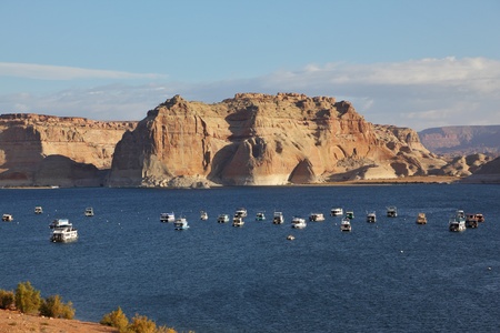 Flotilla of elegant white yachts on Lake Powell. Small waves on the lake from the evening breezeの写真素材