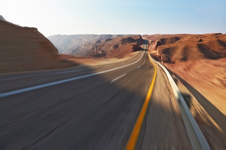Trip driving on high speed on highway in stone desert. A sunsetの写真素材
