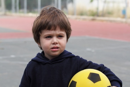 A lovely little boy played with a yellow ball on the playground
の写真素材