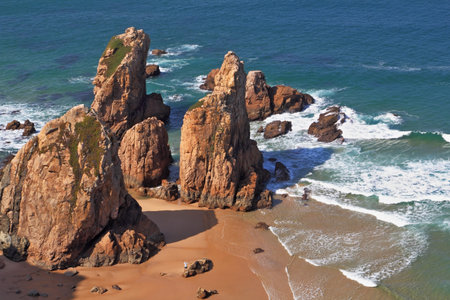 Picturesque rocks on a lonely beach of Atlantic ocean. Coast of Portugal, cape Cabo da Roca  - the most western point of Europe. Morning, sunriseの写真素材