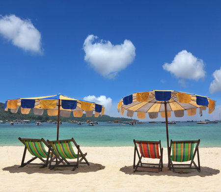 Beach paradise on the Krabi, Thailand. Colorful parasols and deck chairs are waiting for convenient...