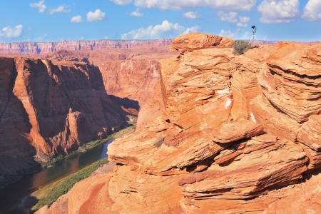 Tripod for shooting on a steep and dangerous shore of the Colorado River.   The well-known river Colorado is picturesquely bent in the Horseshoeの写真素材