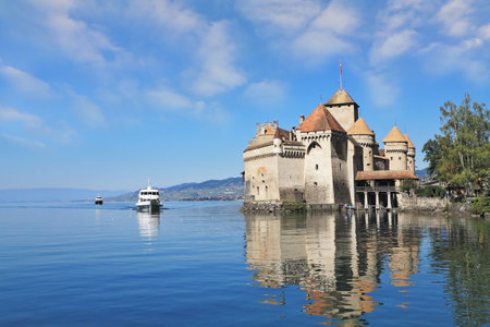  The white tourist motor ship floats by a magnificent medieval castle  World-wide well-known Ch&Atilde,&cent,teau de Chillon on Lake Genevaのeditorial素材